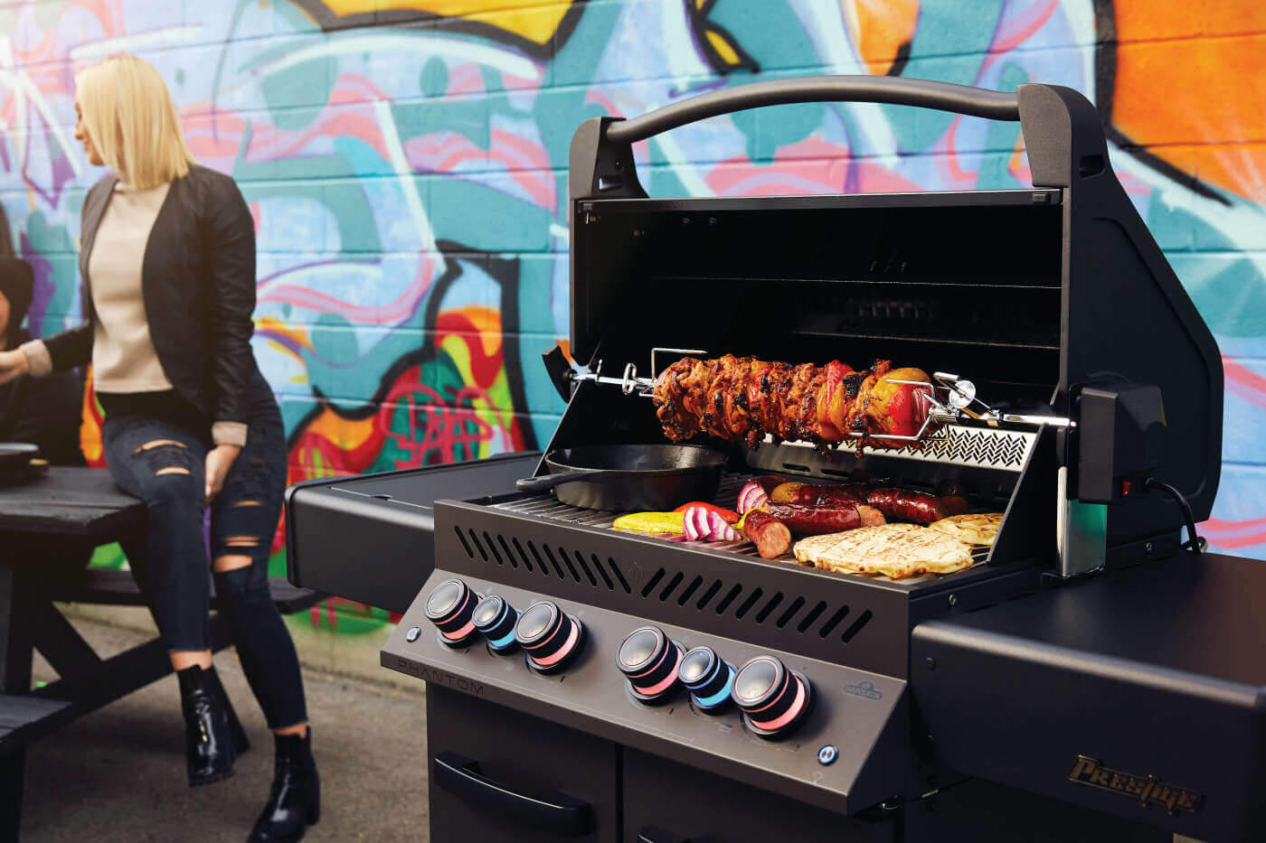 Napoleon Phantom Grill mit Drehspieß und frisch gegrillten Speisen